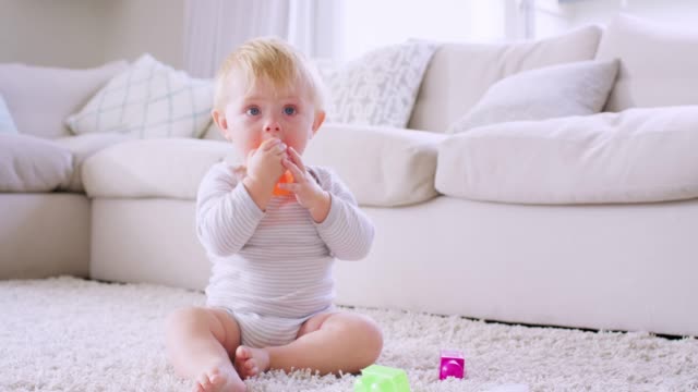 White-toddler-boy-sitting-on-floor-playing,-close-up