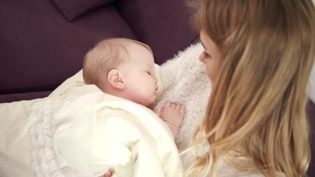 Entzückende-Baby-schlafen-auf-Mutter-Hände.-Kleinkind-in-Umarmung-Mutter-schlafen