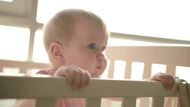 Cute-baby-standing-in-cot.-Cute-childhood.-Toddler-girl-in-crib