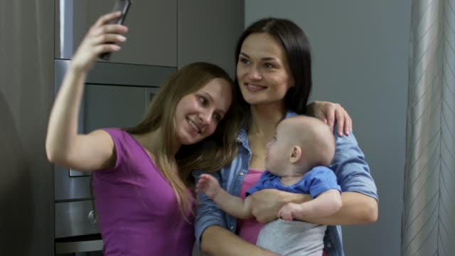 Glückliche-Frauen-mit-Baby-nehmen-Selfie