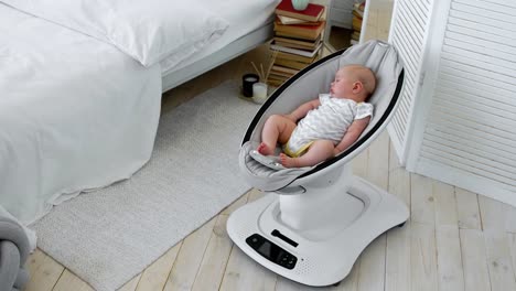 Baby-schläft-in-einem-Schaukelstuhl-für-Kinder-Hightech-Design-in-weiße-Schlafzimmer