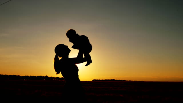 Silhouette-of-mother-with-child-at-sunset