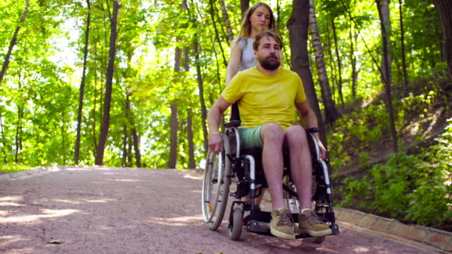 Young-disable-man-on-a-walk-in-the-park-with-his-wife