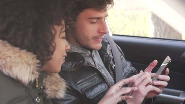 Couple-using-navigation-on-mobile-phone-in-car