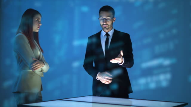 Der-Geschäftsmann-und-eine-Geschäftsfrau,-die-mit-einem-Hologramm-arbeiten