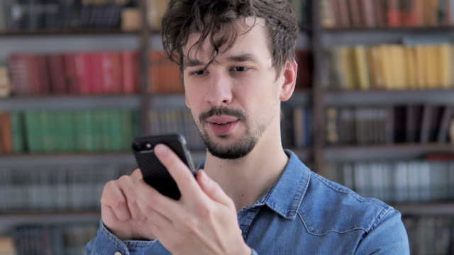 Portrait-of-Casual-Young-Man-Busy-Using-Smartphone