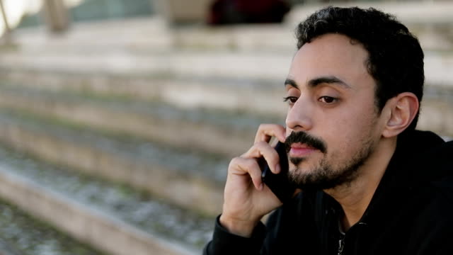 Nahaufnahme-junger-arabischer-Männer-steht-vor-dem-Telefon-draußen