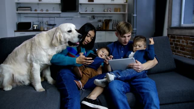 Die-Familie-der-Familie-mit-Haustierhund,-die-auf-dem-Sofa-ruht,-ist-ein-sehr-bestiger