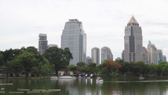 Paisaje-urbano:-árboles-verdes-y-gran-lago-frente-a-rascacielos-en-el-centro-de-la-ciudad.-Rise-edificios-y-el-parque-de-la-ciudad-en-el-horizonte