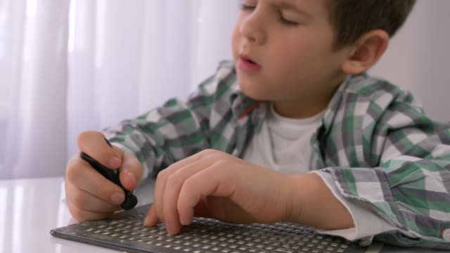 Educación-de-los-niños-ciegos,-niño-enfermo-aprendiendo-a-escribir-caracteres-Braille-fuente-en-la-mesa-en-brillante