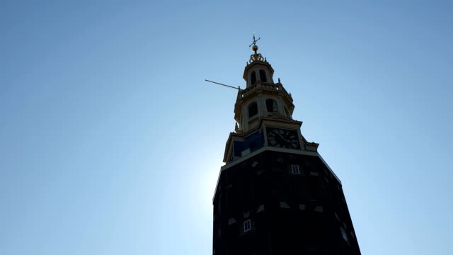 Uhrenturm-Montelbaanstoren-aus-dem-Tourboot-entfernt.-Montelbaanstoren-Tower-auf-blauem-Himmelshintergrund,-Zufall-aus-dem-Turm-und-strahlt-in-die-Kamera