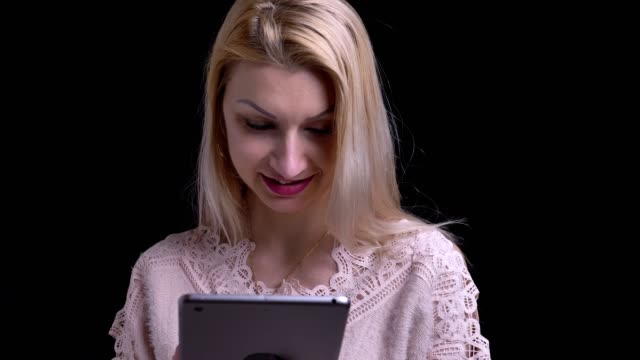 Nahaufnahme-von-mittleren-Alter-kaukasischen-Frau-mit-dem-Tablet-dann-in-die-Kamera-schauen-und-lächelnd