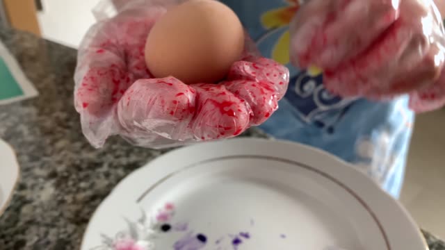 Eine-Frau-in-Handschuhen-malt-Eier