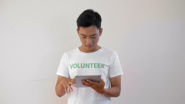 Voluntario-Asiático-Masculino-con-Tablet