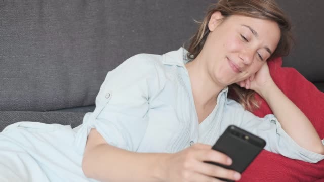 Lächelndes-Mädchen-hält-Smartphone-in-der-Hand-zu-Hause