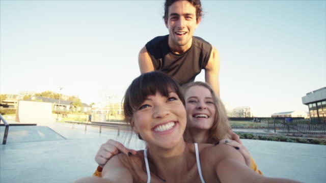 Amigos-creando-un-divertido-video-en-el-parque-de-skateboard.