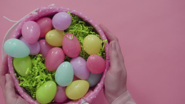 Cesta-de-Pascua-con-huevos-de-Pascua-sobre-fondo-rosado.