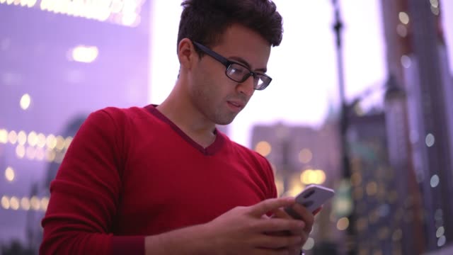 Elegante-tipo-hipster-leyendo-mensaje-en-el-teléfono-inteligente-y-chateando-en-las-redes-sociales-utilizando-la-conexión-a-Internet-4G
