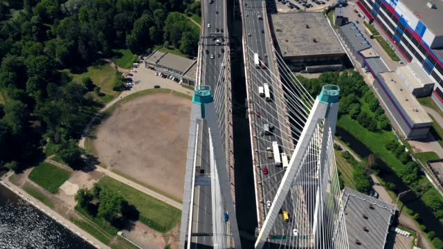 Aerial-or-top-view-from-drone-of-concrete-bridge-with-asphalt-road-or-highway-over-big-river-with-city-car-traffic,-urban-transportation,-toned