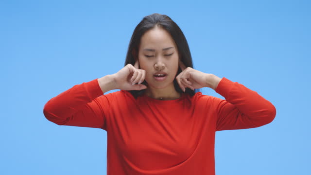 Mujer-joven-tapando-oídos-con-los-dedos