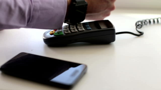Joven-empresario-paga-usando-el-sistema-inalámbrico-NFC-en-un-restaurante
