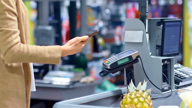Supermarket,-contactless-payment-for-purchases-at-the-checkout.-Hand-brings-the-phone-to-the-payment-terminal,-nfc.-4k,-ProRes