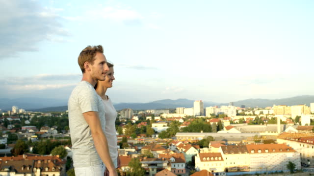 CLOSE-UP:-Boyfriend-pointing-with-fingers-showing-city-to-girlfriend-at-rooftop