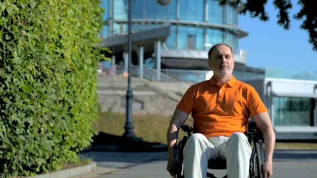 Serious-senior-man-using-wheelchair-outdoors