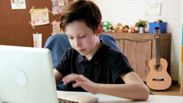 Niedliche-kleine-Junge-Tippen-auf-Tastatur-von-seinem-Laptopcomputer