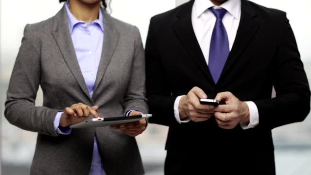 Unternehmer-und-Unternehmerin-mit-Smartphones-im-Büro