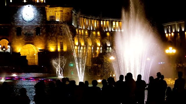 Tourists-observe-Musical-Fountain-near-Great-government-building,-Dating-clock