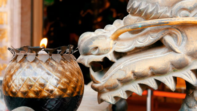 Ursprüngliche-Kerze-im-chinesischen-Stil.-Bronzestatue-von-einem-Drachen-und-einer-brennenden-Kerze-in-der-Nähe