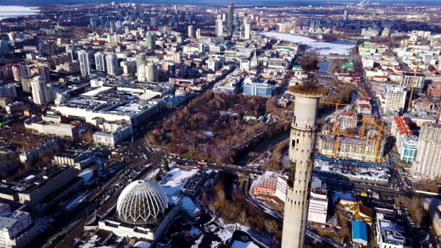 Aerial-view-on-abandoned-TV-tower-in-Yekaterinburg.-Clip.-Aerial-view-of-abandoned,-old-building,-TV-tover-or-communication-tower-with-city-landscape-background