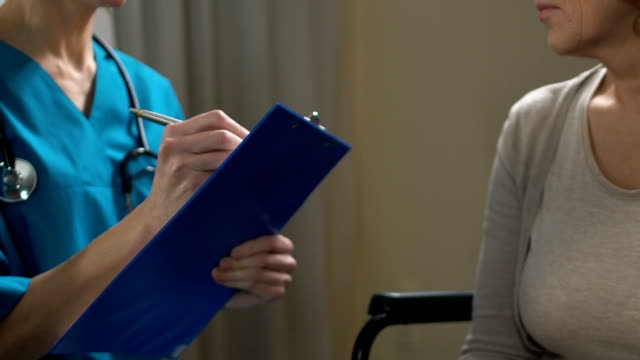 Mujer-enfermera-rellenando-papeles,-poner-la-mujer-con-discapacidad-en-lista-de-voluntarios