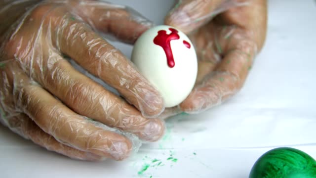 Applying-a-red-paint-on-an-egg