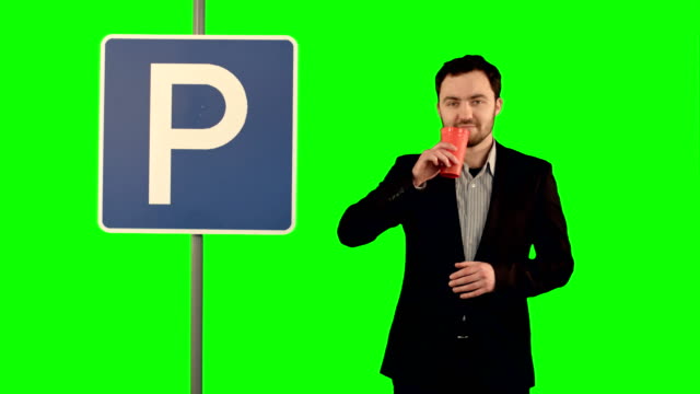 Hombre-con-una-taza-de-té-cerca-de-señal-de-aparcamiento-en-una-pantalla-verde