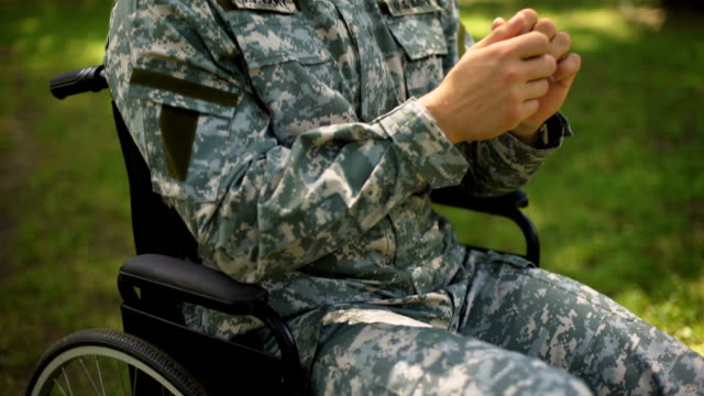 Paralyzed-american-soldier-praying-in-wheel-chair,-asking-for-help,-problem