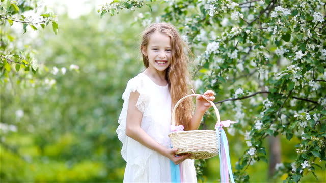 Entzückende-kleine-Mädchen-in-blühender-Apfelgarten-an-schönen-Frühlingstag