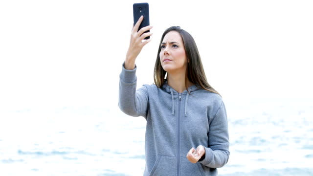 Teen-searching-phone-coverage-on-the-beach