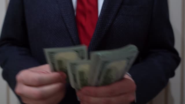 Business-Mann-zieht-sich-hundert-Dollar-Scheine-aus-Jacke-innen-Tasche-und-zählen