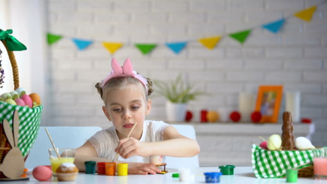 Left-handed-girl-brushing-Easter-eggs-with-paint,-creativity,-childrens-hobby