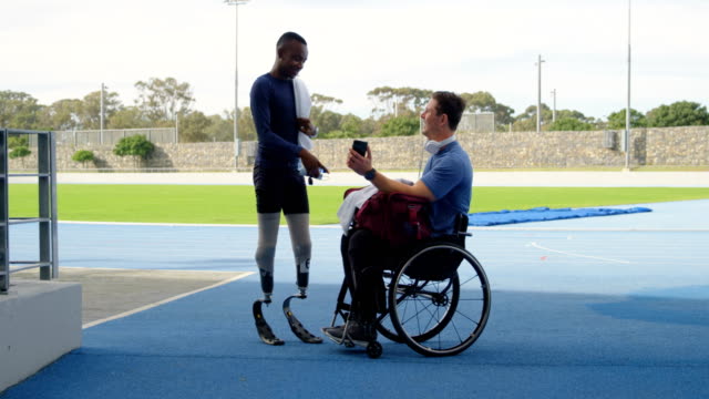 Two-disabled-athletics-discussing-over-mobile-phone-4k