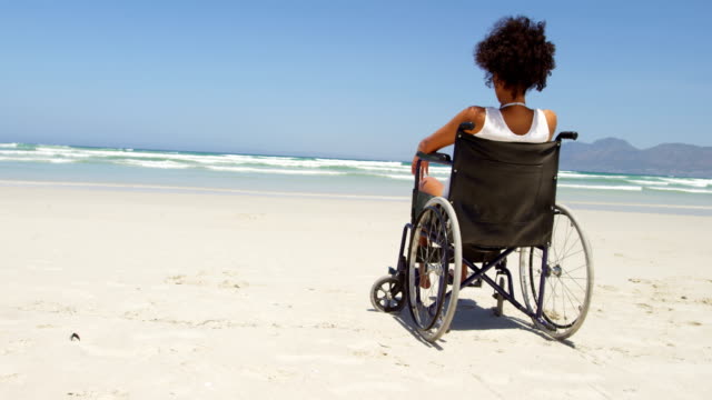 Behinderte-Frau-sitzt-auf-dem-Rollstuhl-am-Strand-4k