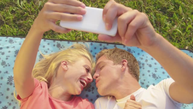 CLOSE-UP:-Adorable-newlyweds-kiss-as-they-lie-on-the-blanket-and-take-selfies.
