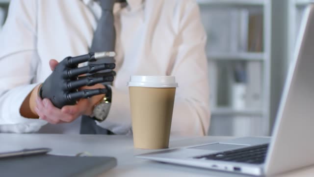 Businessman-with-Robotic-Prosthetic-Arm-Working-in-Office