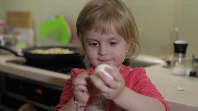 Closeup-of-a-little-girl-cleans-the-shell-with-a-boiled-chicken-egg