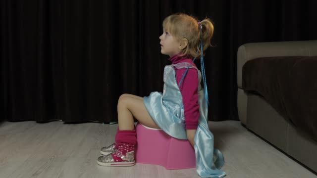 Little-girl-sitting-on-the-potty-and-watching-TV