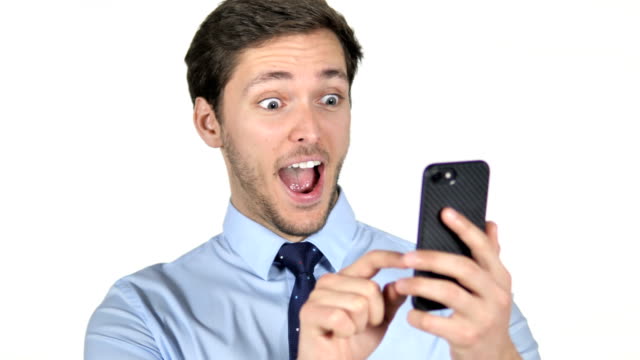 Young-Businessman-Celebrating-Success-while-Using-Smartphone-on-White-Background