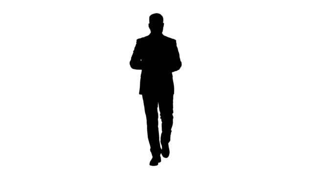 Silhouette-Businessman-walking-and-swiping-pages-on-his-tablet-computer-and-looking-to-camera-presenting-something