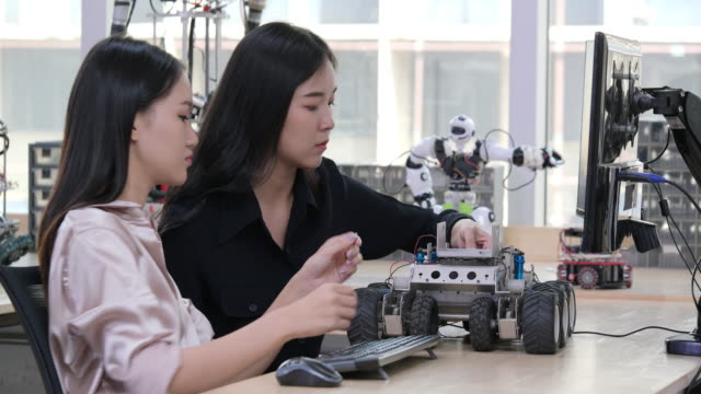 Weibliche-Elektronik-Ingenieur-versuchen,-Roboter-im-Labor-zu-beheben.-Technologie--und-Innovationskonzept.